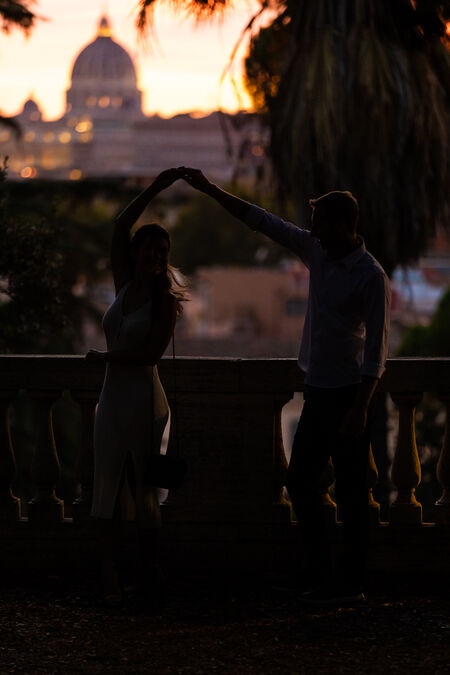 Newly-engaged couple dancing at in the blue hour at the Pincio Gardens with the Vatican in the background