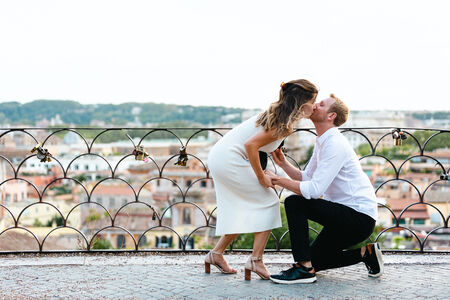 Lady kissing his fiancé during their surprise proposal photo shoot on the Terrazza Belvedere in Rome