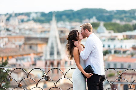 Newly-engaged couple kissing on the Terrazza Belvedere at sunset in Rome