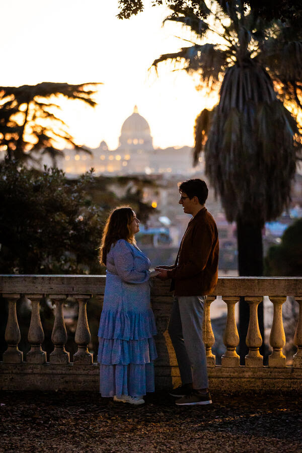 newly-engaged couple holding hands at sunset at the Pincio Gardens with the Vatican in the background