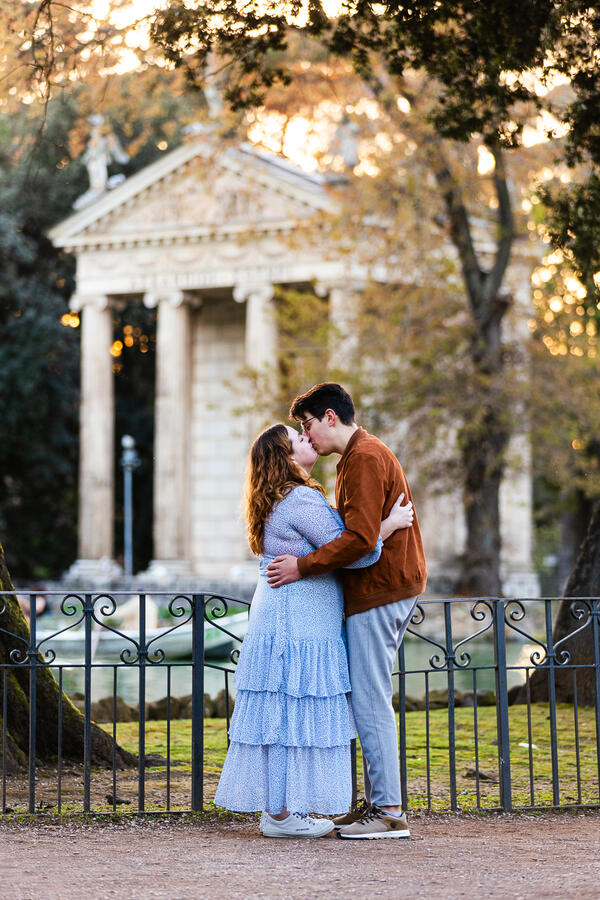 Newly-engaged couple kissing by the lake in Villa Borghese in Rome