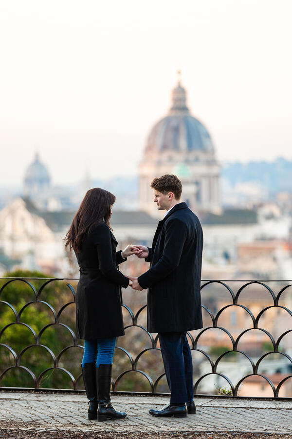 Young couple holding each other's hands on the Terrazza Belvedere moments before their surprise proposal in Rome