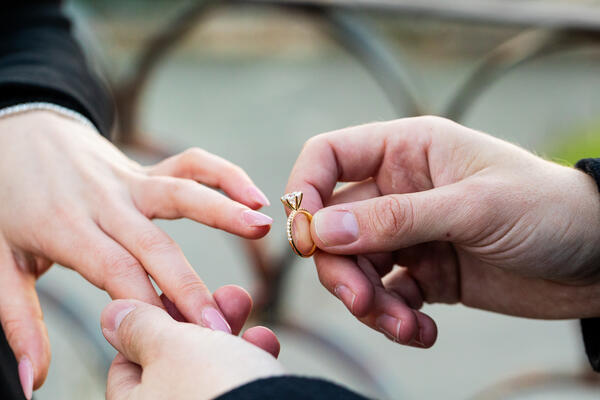 Close-up of engagement ring being put on during a surprise wedding proposal in Rome