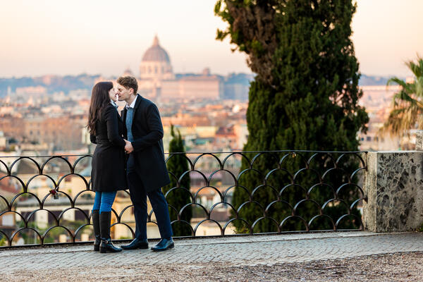 Young couple kissing each other during a declaration of love on the Terrazza Belvedere in Rome